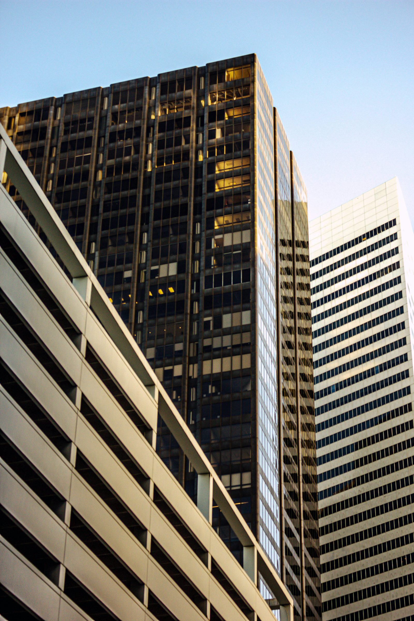 Financial-district office towers seen from below, their glass facades meeting in receding vertical lines